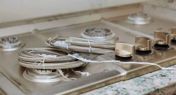 Flexible appliance connector fitted to stainless steel hob